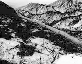 Photo:  Troops of Heavy Mortar Co., 32nd Regiment, 7th Division, move into position in a pass between Punggi and Tanyang, Korea. 