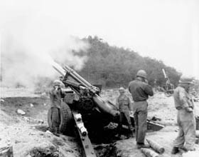 Photo:  A gun crew from Company "A", 90th Field Artillery Battalion, 24th U.S. Infantry Division, fires a 155-mm  howitzer.