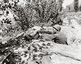 Pfc. Letcher V. Gardner (Montgomery, Iowa), Co D, 8th Cavalry, 1st Cavalry Division, fires on an emplacement of the Communist-led North Koreans, along the Naktong River, near Chingu.