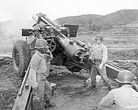 Photo:  Men of Battery C, 936th Field Artillery Battalion, U.S. Eighth Army, fire the 200,000 round of ammunition from their 155-mm howitzer during action against the Chinese Communist forces in Korea.