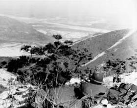 Photo:  Pfc. Miles Adair of Leon, Io, (left) and Sgt. Norbert Brzycki of Chicago, Ill., infantrymen of the 5th RCT, dig in on a hill.