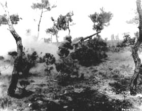 Photo:  Cpl. Thomas E. Bullis of Troy, N.Y., gunner, and Pfc. Charles R. Gilman of Peroria, Ill., assistant gunner, fire their 57-mm recoilless rifle at a Chinese Communist pillbox.