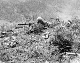 Photo:  Two light machine gunners cover men of the 187th RCT.