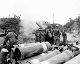 Photo:  An 8-inch howitzer of Battery B, 720th Field Artillery Battalion, U.S. X Corps, fires at the Chinese Communists near Yanggu, Korea.