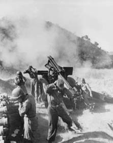 Photo: Men of Battery C, 936th Field Artillery Battalion, U.S. Eighth Army, fire the 100,001st and 100,002d shell at Chinese Communist position near Choriwon, Korea.