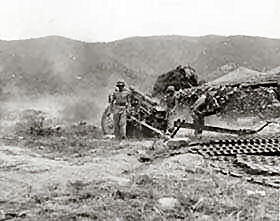 A Field Artillery Battery of the 8th F/A, 25th Division fires on a North Korean road block with a 105-mm howitzer.