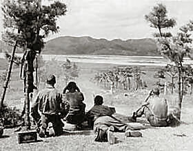 A .50 Cal. Machine gun squad of Co. E, 2nd Battalion, 7th Regiment, 1st Cavalry Division, fires on North Korean patrols along the north bank of the Naktong River, Korea.