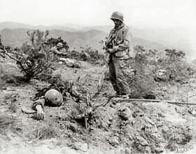Sgt. Herbert Ohio of Hilo, T.H., views the battered remains of the Communist defenders of Hill 268, which was taken by men of the 5th RCT, 1st Cavalry Division in their advance on Waegwan, Korea.