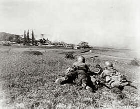 A .30 caliber light machine gun crew of the 5th RCT, 1st Cav. Div., fires on Communist-led North Koreans, as they push toward Taejon, Korea.