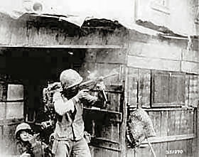 A member of the United Nations troops fires a submachine gun on Communist-led North Korean forces, during fighting in streets of Seoul.