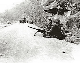 A machine gun team of an X Corps military police company goes into action to relieve a convoy pinned down by fire of the Chinese Communists, in Korea.