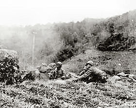 A patrol of Co. C, 65th Infantry Regiment, 3rd Infantry Division, fire light machine guns on Chinese Communist troops located in the hills near Haejung, North Korea. Sfc. Forsyth, who photographed the action, was wounded shortly after recording this picture.