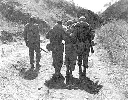 Photo, Wounded 25th Division infantryment escorted to an aid station