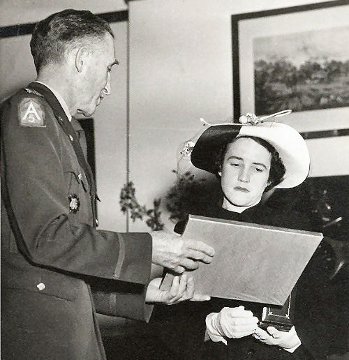American Military Attache presenting Lt. Col. Hercules Green's posthumous Silver Star for gallantry to Olwyn Green