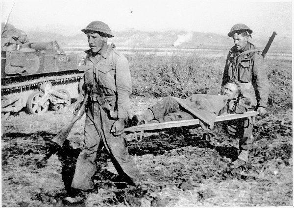 Snow Dicker borne on stretcher after wounded, through terrain still observed by enemy